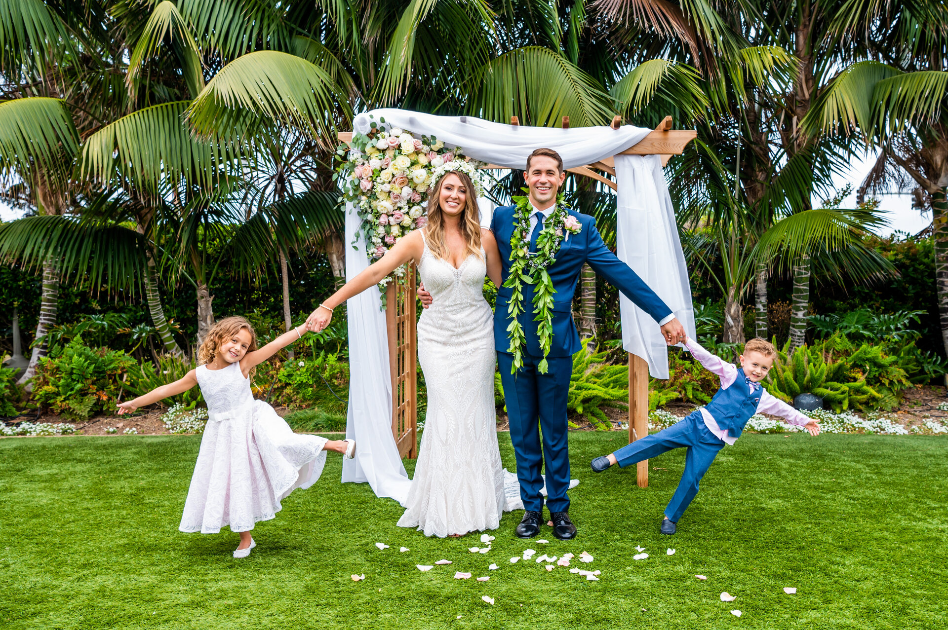 wedding couple holding hands with two children